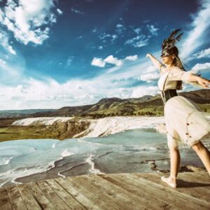 A graceful ballet dancer performs an elegant pose at Pamukkale's stunning travertine terraces.